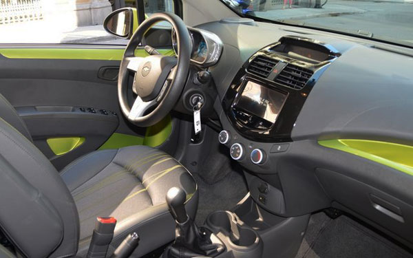 <strong>Photo: 2013 Chevrolet Spark (interior / front).</strong> Inside, the The Spark has decorative inserts on the dashboard and in the front door, which together with its icy blue color lights give it a touch of top quality. The Spark 2LT version also has steering wheel and heated seats leather wrapped.
